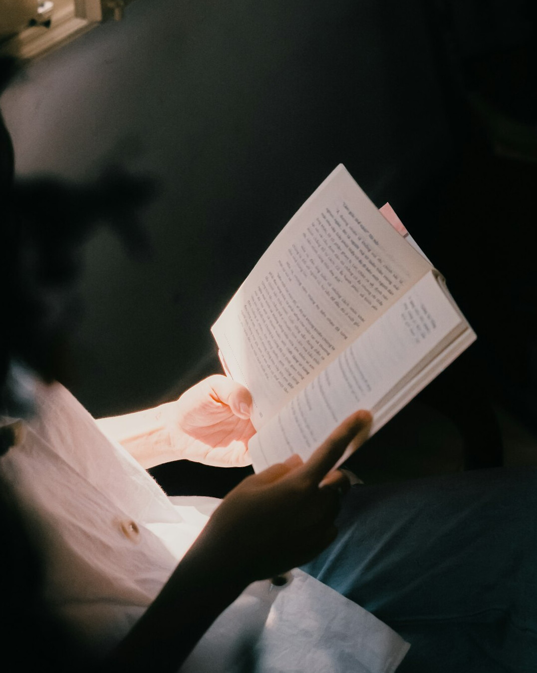 woman reading mystery book at night